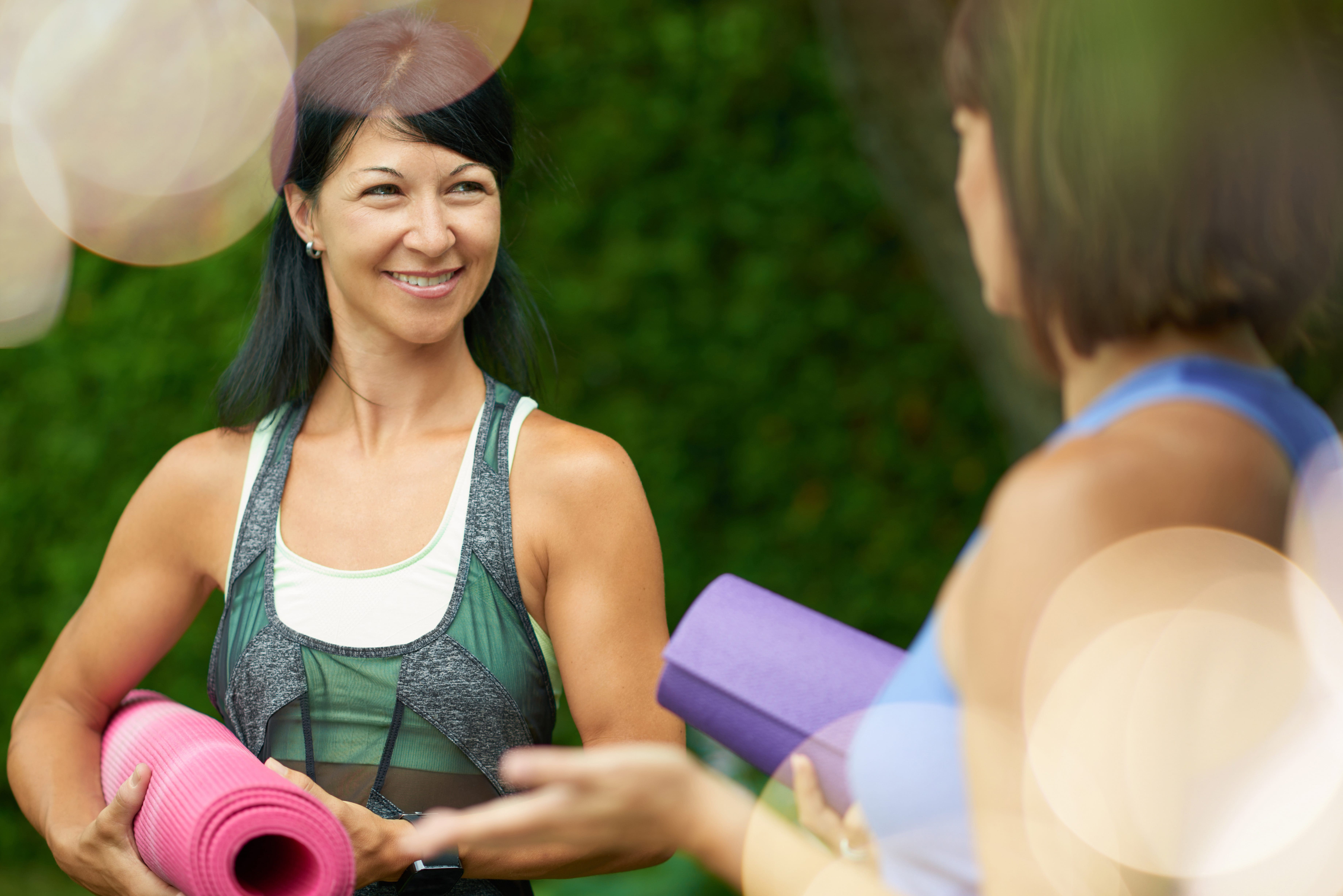 two women having a talk at a yoga class
